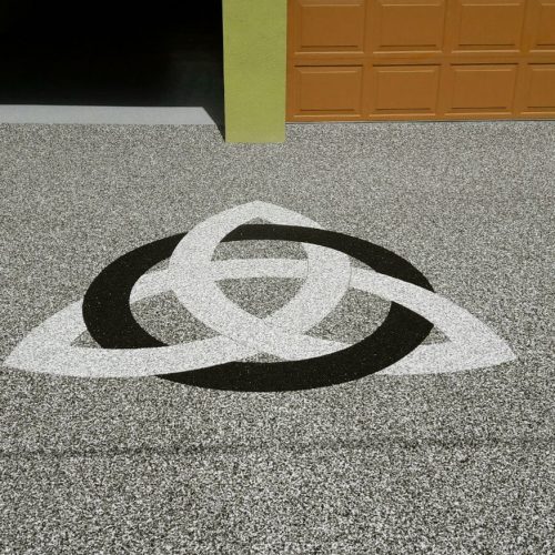Garagenzufahrt mit Steinteppich. Der im Boden dargestellte Knoten war der Wunsch des Bauherrn.