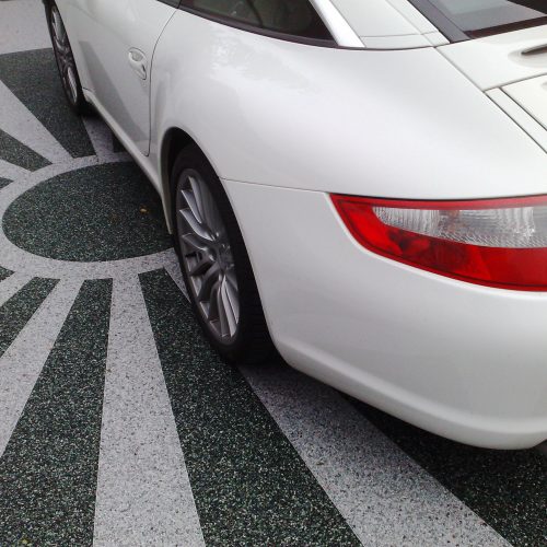 Steinteppich auf Carport mit asiatischer Sonne. Darauf parkt ein Porsche 911 Targa 4s