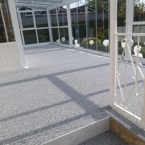 Nebelgrau Steinteppich im lichtdurchfluteten Wintergarten