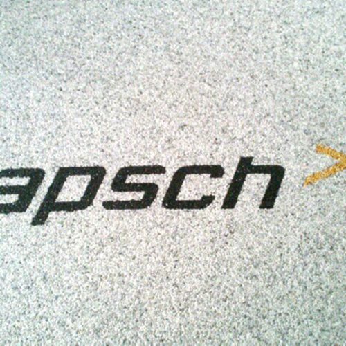 Steinteppich im Empfangsbereich der Firma Kapsch mit dem Firmenschriftzug im Boden.