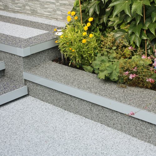 Steinteppich Detailaufnahme zeigt die Anwendung des Terrassenprofils als Terrassen- bzw. Mauerkronenabschluss.