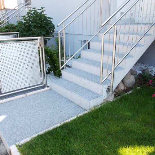 Hauszugang mit Stufen und Müllplatz mit Steinteppich belegt. Farbe nebelgrau.