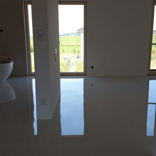 Eine glänzende Bodenbeschichtung, die das Fensterlicht reflektiert.