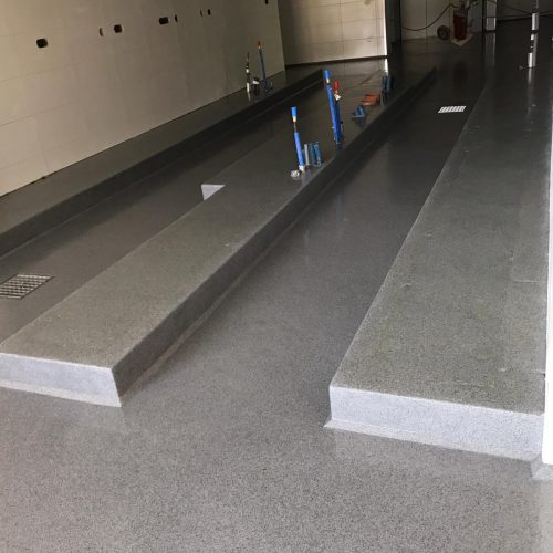 Bodenbeschichtung für Küchen mit grauer Sandmischung und transparentem EP Harz. Die Sockel wurden komplett überbeschichtet.