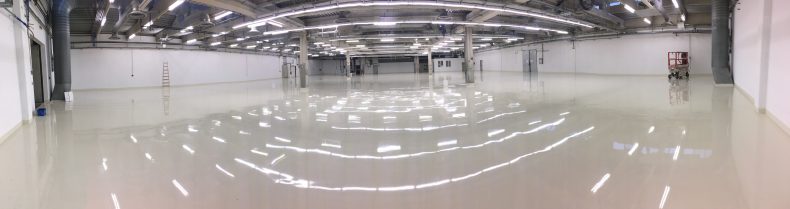 Eine 2000 m² große Industriehalle mit einer glatten Bodenbeschichtung in perlweißer Farbe