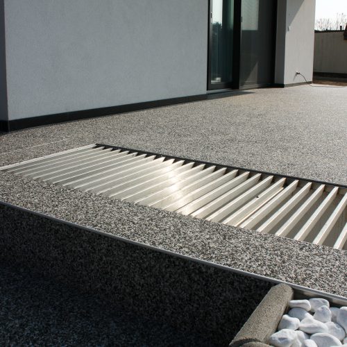 Natursteinteppich auf Terrasse mit eingebundenem Lichtschacht mit massiven Niro Formrohren ausgeführt.